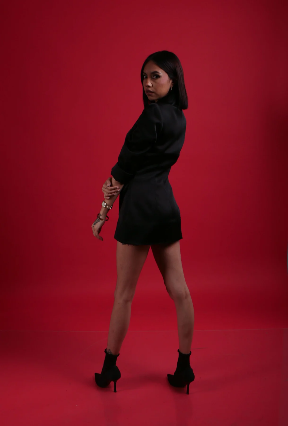 Fashion model in black against a vivid red background